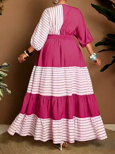 Back view of a plus size bohemian maxi dress with magenta stripes and tiered skirt design