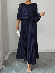 Elegante marineblauwe maxi-jurk met gebloemde mesh cape en geplooide rokdetail