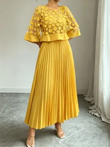 Detail van de gele mesh top met bloemen en de plissé rokstof voor een zomers setje.