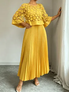 Elegante gele avondjurk met gebloemde mesh top en lange geplooide rok in detailoverzicht