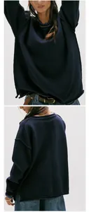 Detail view of a navy blue oversized crewneck knit sweater with raw seam edges.