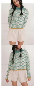 Detail of green floral knit sweater with long sleeves and yellow hem detail