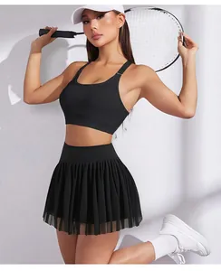 Dettaglio della gonna da tennis nera a vita alta con mesh e pantaloncini sul modello.