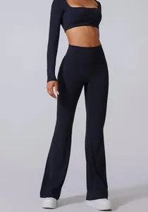 Detail of black high-waisted flared yoga pants and matching long-sleeve crop top