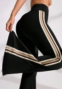 Detailed view of black flare yoga pants showing side stripes and stretchable fabric