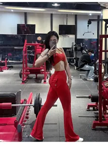 Vue d'ensemble d'un pantalon de yoga évasé rouge à taille haute avec poches en salle.