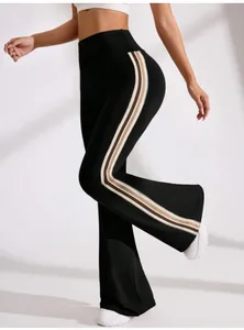 Detail view of high waist flared yoga pants with stylish tri-color side stripes