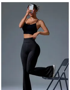 Schwarze Yoga-Hose mit hoher Taille und ausgestelltem Bein am Model im Studio
