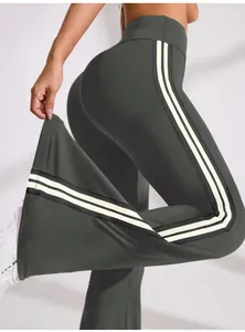 Side view detail of high-waisted flared yoga pants with white stripes on the side