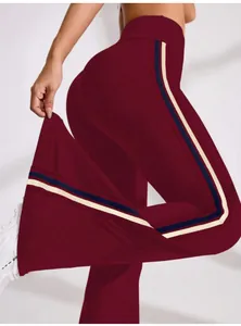 High-waisted burgundy flare yoga pants with side stripes for athletic workout wear.