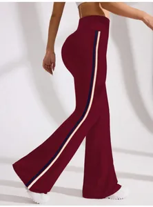 Side view of high-waisted burgundy flared yoga pants with navy and cream stripes