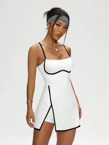 Detail view of a white tennis dress with black contrast piping and split A-line skirt.