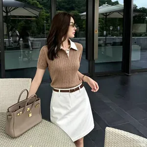 Gros plan d'une femme portant un polo vintage en maille torsadée marron avec col blanc