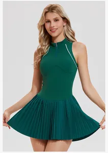 Detailed view of a green pleated tennis dress with quarter-zip and elegant white piping.