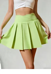 Detailed view of lime green pleated tennis skirt showing crossover high waist design.