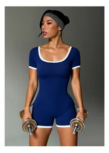 Modella indossa tuta sportiva blu a coste con bordi bianchi a contrasto e scollo tondo.