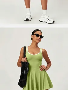 Model wearing a vibrant green athletic tennis dress with white sneakers and bag detail