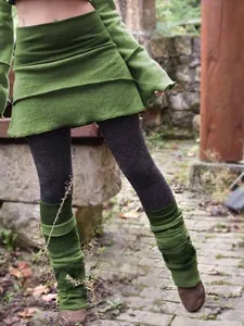 Detail of color-block irregular leggings skirt with layered green hem and grey tights