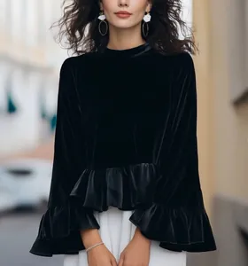 Close-up detail of luxurious black silk velvet blouse with ruffle hem and bell sleeve