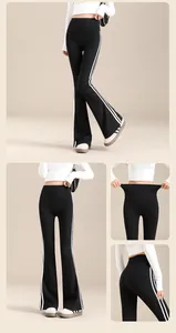 Detailansicht der ausgestellten High-Waist-Yogahose mit weißen Seitenstreifen und Elastizität.