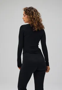 Back view of a sleek black long-sleeve yoga top with tie-back detail for pilates