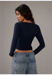 Detailed back view of a navy blue long-sleeve yoga wrap top featuring tie-up waist detail