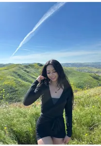 Close-up detail of a women's black breathable wrap yoga top worn in a scenic outdoor setting