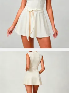 Detail showing the back and front waist design of a cream tennis dress with belt.