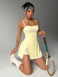Detailed view of a yellow tennis dress with white contrast piping and slit skirt