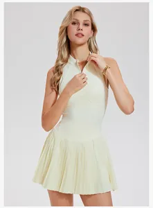 Sleeveless pale yellow tennis dress with half-zipper collar and pleated skirt detail
