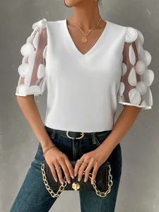 Close-up of elegant white V-neck blouse featuring sheer bubble sleeves with 3D polka dots