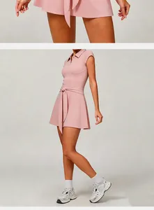 Detailed view of a pink athletic tennis dress featuring a polo collar and tie-waist design