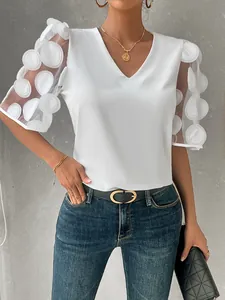 Detail view of white V-neck blouse with sheer 3D circular dot puff sleeves