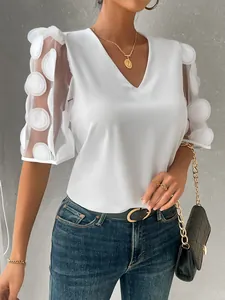 Detailed view of elegant white V-neck blouse with 3D dot textured sheer puff sleeves