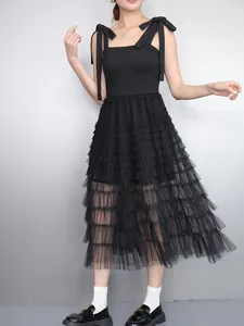 Elegant sleeveless black tiered mesh dress featuring bow straps and a ruffled skirt