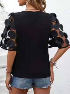 Rear detail of black blouse featuring sheer mesh sleeves with 3D polka dot appliqués