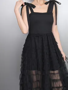 Close-up of elegant black mesh ruffled dress featuring stylish bow tie shoulder straps