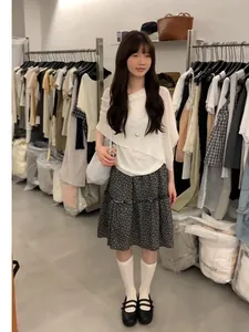 Elegant Korean-style two-piece set featuring a white asymmetric top and floral midi skirt