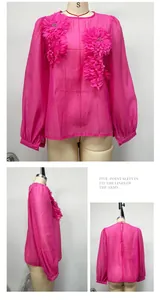 Detail views of fuchsia pink blouse with 3D floral appliqués and lantern sleeves.