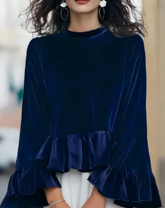 Detailed view of a dark navy blue velvet blouse featuring elegant ruffled sleeves and hem.
