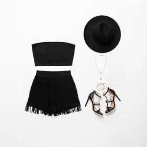 Détail d'un ensemble bohème noir avec short à franges et accessoires.