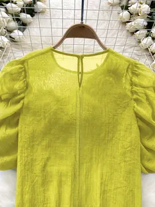Detail view of yellow sheer chiffon lantern sleeve blouse with back neck button closure