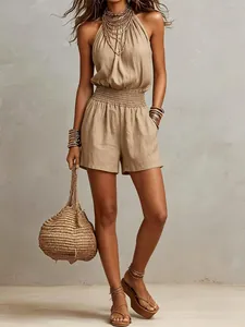 Elegante mono corto de mujer beige en lino sin mangas con bolso trenzado y joyas