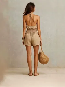 Vista trasera de un elegante mono corto de lino mezclado caqui con cuello halter para mujer