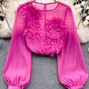 Macro view of elegant 3D flower appliqué on magenta sheer chiffon lantern sleeve top