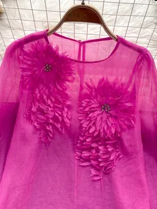 Macro detail of elegant 3D floral appliques and rhinestones on sheer pink chiffon top