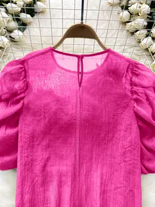 Detailed view of an elegant sheer magenta chiffon blouse featuring stylish puff sleeves.