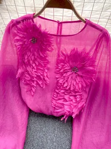 Close-up of vibrant pink chiffon top featuring intricate 3D floral appliques and rhinestones
