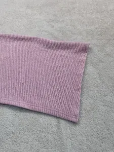 Dettaglio ravvicinato del tessuto strutturato rosa per set traspirante con spalla nuda