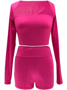 Roze tweedelige set bestaande uit een crop top met lange mouwen en hoge taille shorts